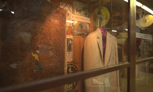 Hanging suit jacket and other memorabilia in a glass case in the Casey Tibbs Museum at 1880 Town